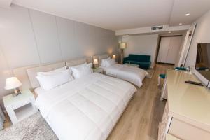 a hotel room with a large white bed and a couch at Demi Hotel in Sarandë