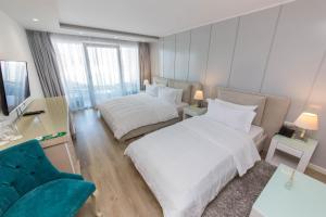 a hotel room with two beds and a couch at Demi Hotel in Sarandë