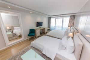 a bedroom with two beds and a large mirror at Demi Hotel in Sarandë