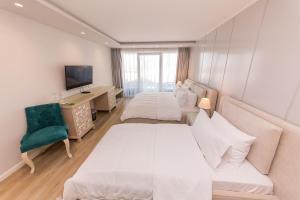 a hotel room with two beds and a couch at Demi Hotel in Sarandë