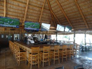 bar z kilkoma krzesłami i telewizorami w obiekcie Looe Key Reef Resort and Dive Center w mieście Summerland Key