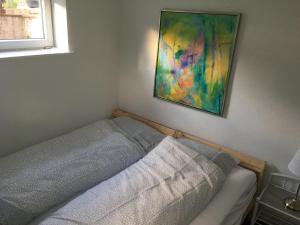 a bed in a bedroom with a painting on the wall at Give Family Apartment in Give