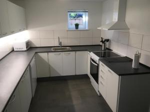 a white kitchen with a sink and a stove at Give Family Apartment in Give