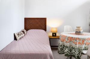 1 dormitorio con 1 cama y 1 mesa con lámpara en Cozy & peaceful apartment in Chalki en Khalkíon