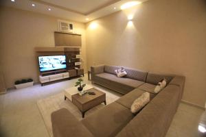 a living room with a couch and a television at Four Seasons Estate in Taif