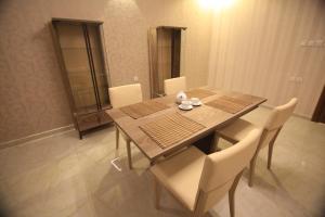 a dining room with a wooden table and chairs at Four Seasons Estate in Taif