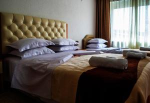 a bedroom with three beds and a large window at Hotel Ajana in Ulcinj