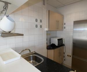 eine Küche mit einer Spüle und einem Kühlschrank aus Edelstahl in der Unterkunft Apartamento Bruselas in Torrox Costa + 5 Fotos