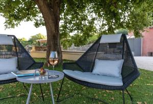 dos sillas de mimbre y una mesa con una copa de vino en Mas du Brulat, en Le Castellet