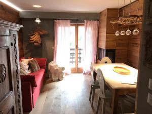 ein Wohnzimmer mit einem roten Sofa und einem Tisch in der Unterkunft APPARTAMENTO SONNE in Ponte di Legno