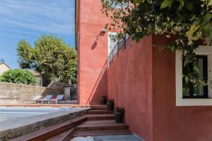 a house with a red wall and stairs at Mas du Brulat in Le Castellet