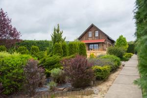 una casa con un jardín delante de ella en Pine Cottage, en Cserszegtomaj