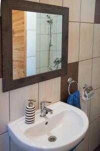 W łazience znajduje się biała umywalka i lustro. w obiekcie Pine Cottage w mieście Cserszegtomaj