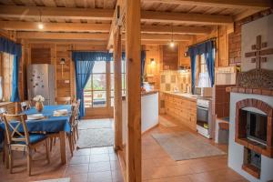 a kitchen and dining room with a table and a fireplace at Pine Cottage in Cserszegtomaj