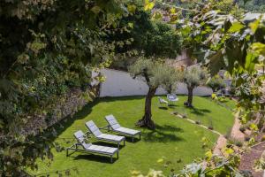 a group of white chairs and a tree in a yard at Mas du Brulat in Le Castellet