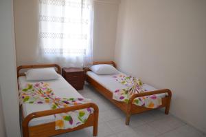 2 camas en una habitación pequeña con ventana en Ahmeda Apart Hotel, en Ayvalık