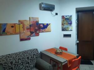 a room with a table and paintings on the wall at Casa LuLù in Catanzaro