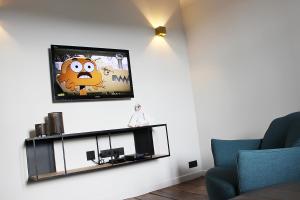 uma sala de estar com uma televisão na parede em Remacle3 em Stavelot