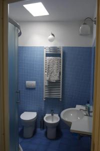 La salle de bains est pourvue de carrelage bleu, de toilettes et d'un lavabo. dans l'établissement AL VILLINO DUSE, à Gênes