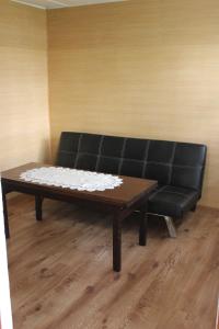 un sofá negro y una mesa de centro en una habitación en Domek w Borkowie, en Borkowo