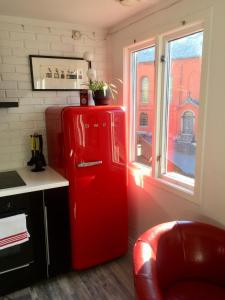 a red refrigerator in a kitchen with a window at Cozee Central Apartments in Stavanger