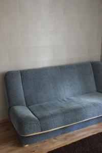 un sofá azul sentado en una sala de estar en Domek w Borkowie, en Borkowo