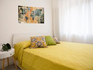 a bedroom with a bed with a yellow bedspread at Milano Navigli Apartment - Zona Tortona in Milan