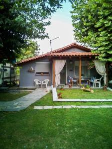 ein kleines Haus mit einer Terrasse und einem Hof in der Unterkunft Sevi Platamon Home in Platamonas