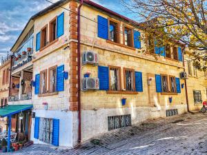 un antiguo edificio con persianas azules en una calle en Mirzade Konak Hotel, en Göreme