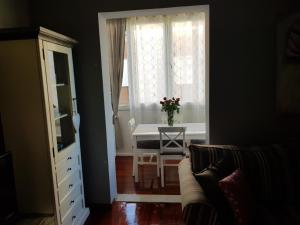 Zimmer mit einem Tisch und einem Fenster mit einer Blumenvase in der Unterkunft Cozy apartment in Rovinj in Rovinj