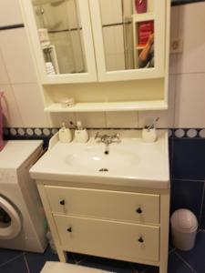 ein Badezimmer mit einem weißen Waschbecken und einem Spiegel in der Unterkunft Cozy apartment in Rovinj in Rovinj