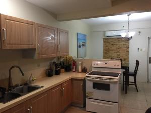 a kitchen with a sink and a stove top oven at Ella's Park View Townhouse Crown Point in Crown Point