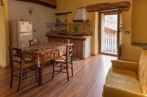 a kitchen with a table and chairs and a refrigerator at Antico Restauro in Fonni
