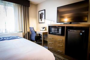 a hotel room with a bed and a tv and a desk at La Quinta by Wyndham Anchorage Airport in Anchorage