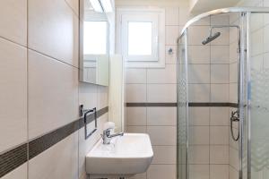 een badkamer met wastafel en douche bij ELENA HOUSE 2 in Gennadi