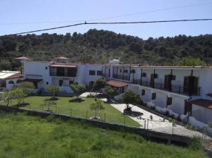 a row of white buildings with a yard at Vontzos Hotel in Achladies