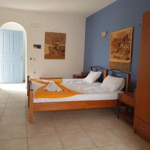 ein Schlafzimmer mit einem großen Bett mit einer orangefarbenen Decke in der Unterkunft Melissa Rooms in Koufonisia