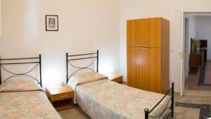 a bedroom with two beds and a wooden cabinet at Casa Vacanze Maria&Vito in Veglie
