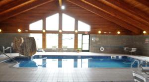 a large swimming pool in a building with a large window at FairBridge Inn & Suites Thorp in Thorp
