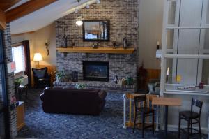 a living room with a fireplace and a couch at FairBridge Inn & Suites in Thorp