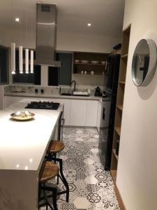 - une cuisine avec un comptoir blanc et une cuisinière dans l'établissement MLA apartments - Buenos Aires, à Lima