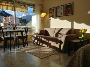 a living room with a couch and a table at Studio avec Parking Privé au Cœur de la Ville in Menton