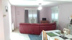een woonkamer met een rode bank en een tafel bij la maison du bonheur in Roquetoire