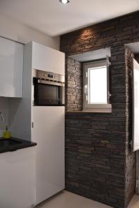 a kitchen with a white refrigerator and a brick wall at Home In the Sea in Sesimbra