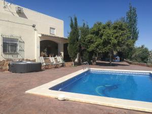a swimming pool in front of a house at Finca San Diego, villa entera para ti in Vallonga
