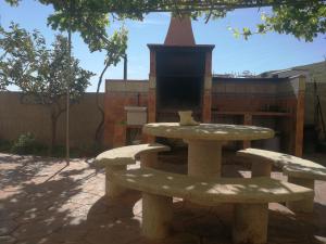a picnic table and two benches in a courtyard at Finca San Diego, villa entera para ti in Vallonga