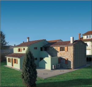 a group of houses with a tree in the yard at Agroturism Stara Štala in Borut