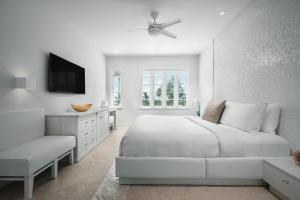 a white bedroom with a bed and a chair at Cardozo Hotel in Miami Beach