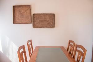 a dining room table with chairs and mats on the wall at Home By The Sea in Sesimbra