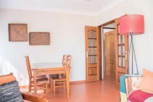 a living room with a table and chairs and a room at Home By The Sea in Sesimbra